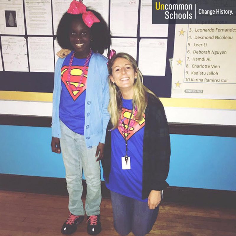 Student and teacher pose in superman shirts