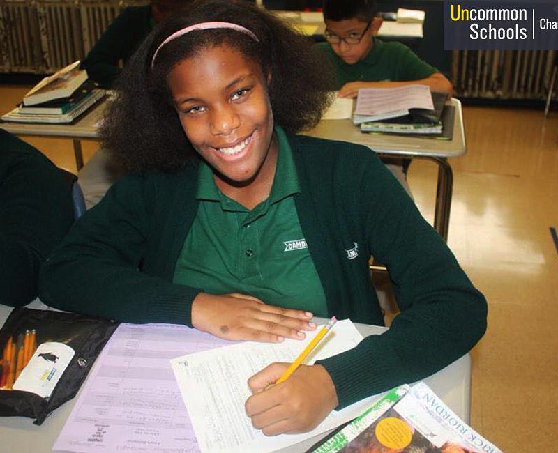 Student smiles at her desk while working