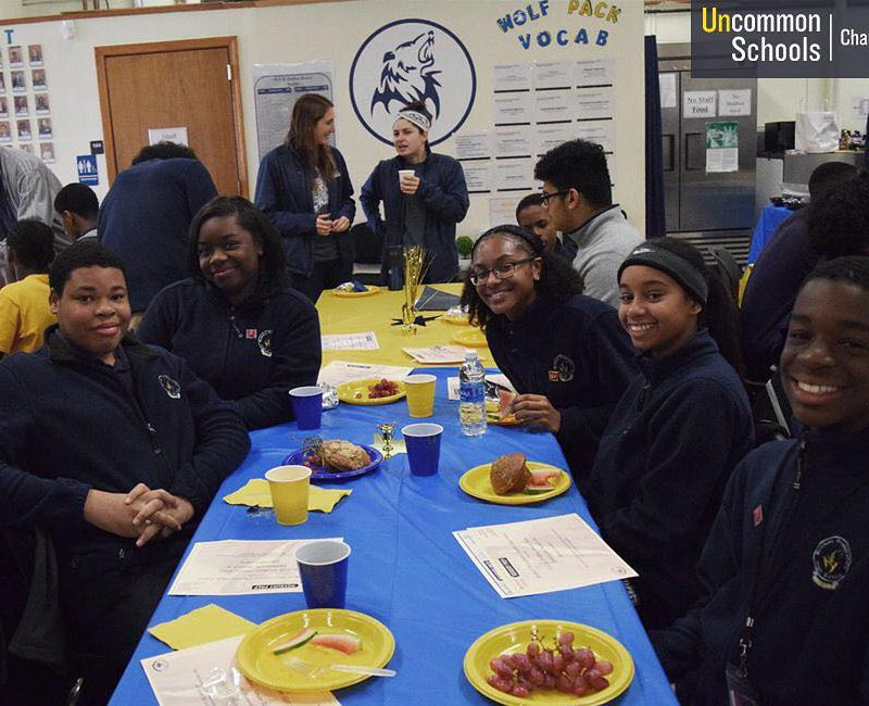 Students sit at a decorated table eating breakfast