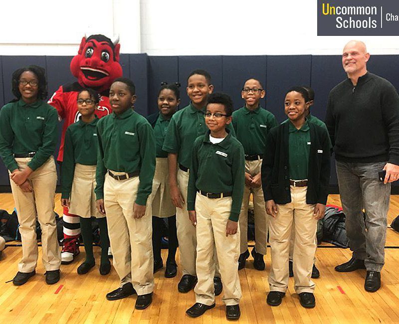 Students pose with NJ Devils mascot and former player Ken Daneyko in school gym