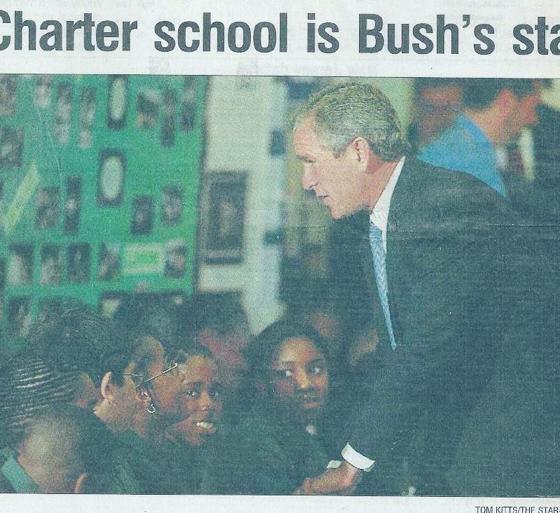 News article with title "Charter school is Bush's star" with photo of George W. Bush shaking students' hands