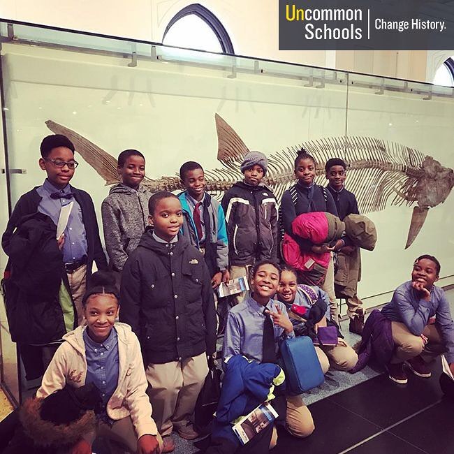 Students pose in front of large fish skeleton