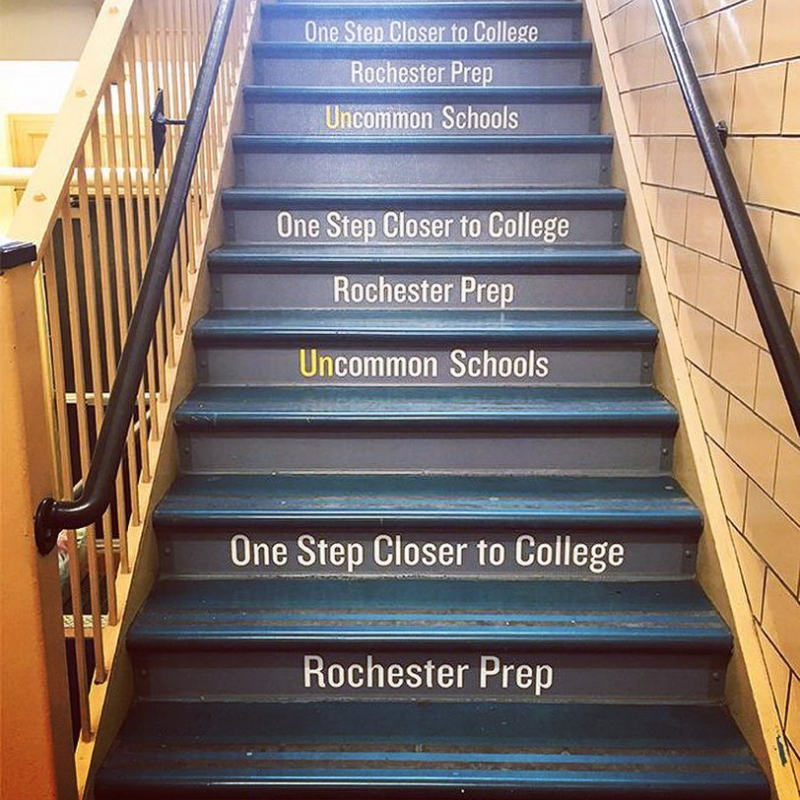 Stairs at Rochester Prep ehich say "One Step Closer to College"