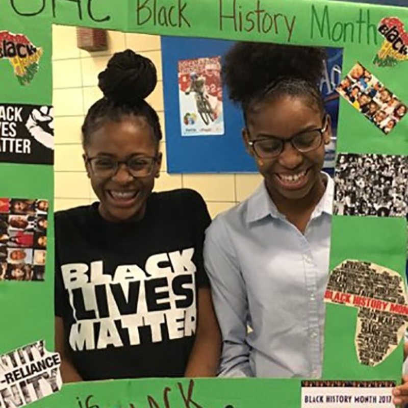 Students pose behind Black History Month frame