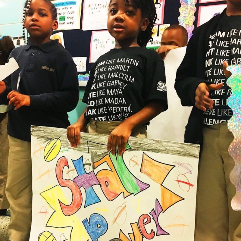 Young student holds sign that reads "Star Power"