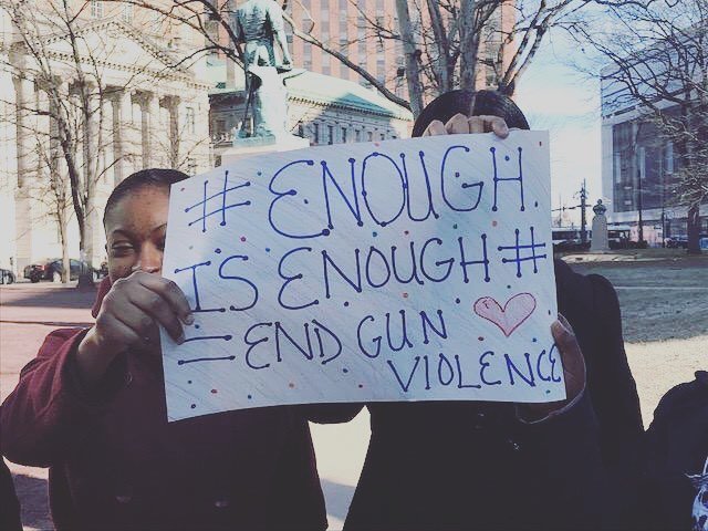 Women hold sign against gun violence