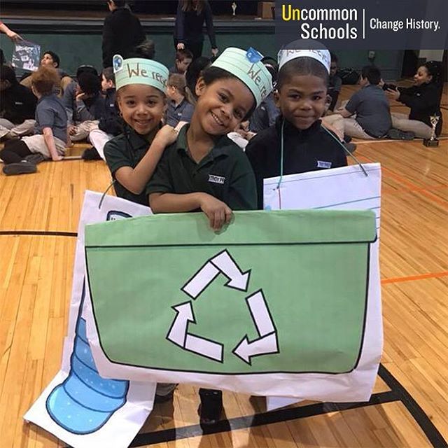 Student pose and smile with recycling signs