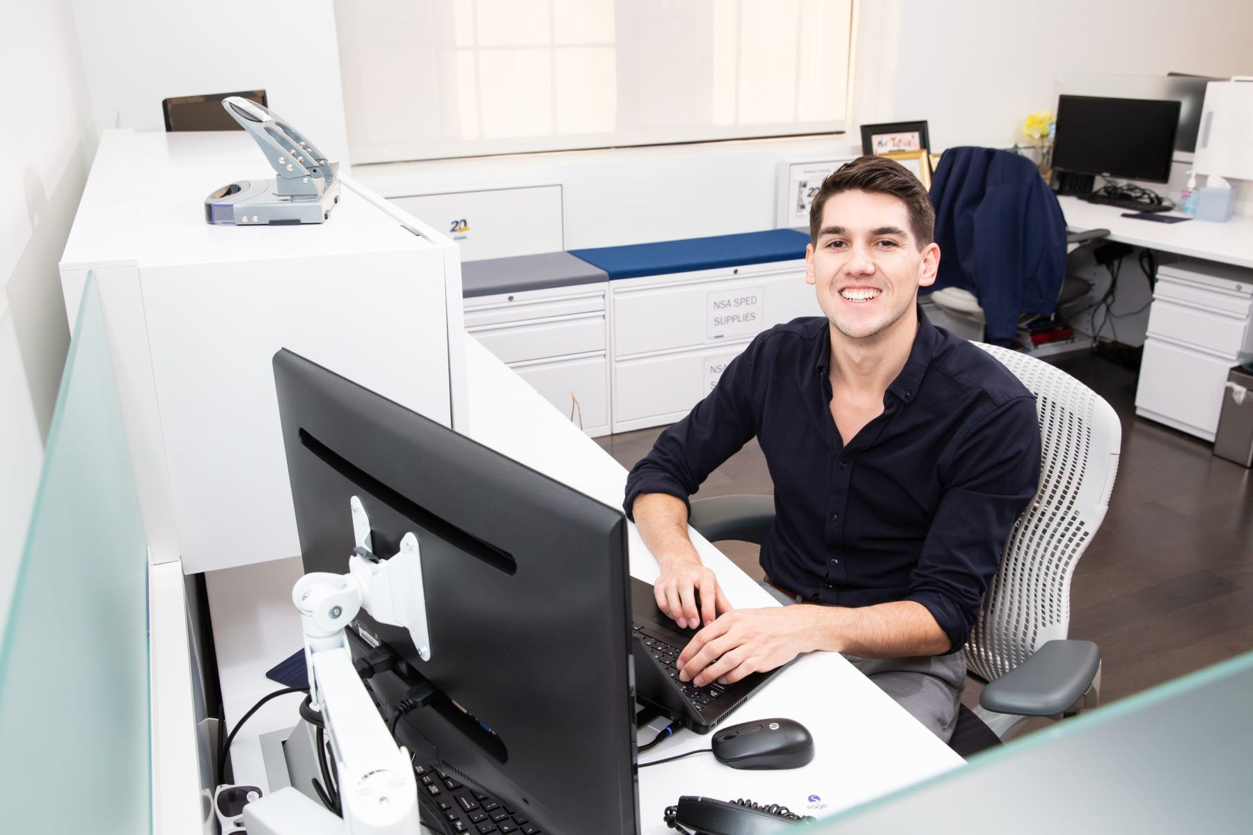 Man in office setting smiling from desk