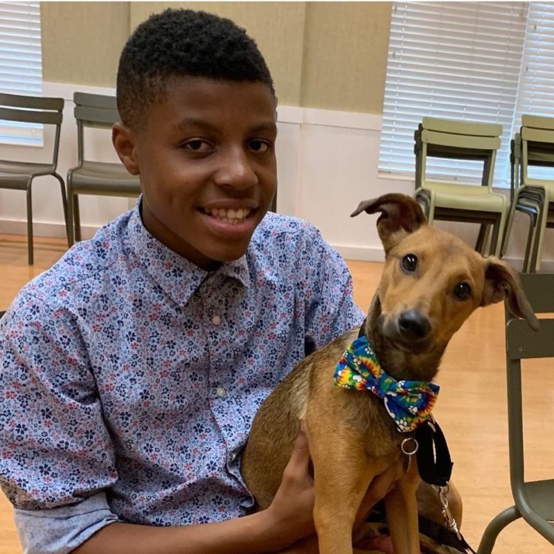 Darius Brown poses with a dog wearing one of his bow ties