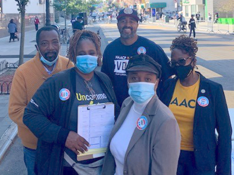 Uncommon Schools staffer Natasha Cherry-Perez, Michael Catlyn of the Coalition of Community Charter Schools, Assemblyman Tremaine Wright and NAACP member Stefani Zinerman on National Voter Registration Day on the Black Lives Matter mural in Brooklyn.