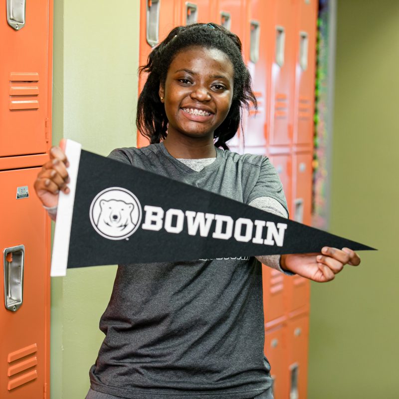 student holding up Bowdoin college flag