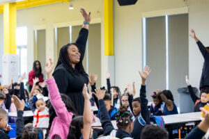 Principal raising hand to alert students